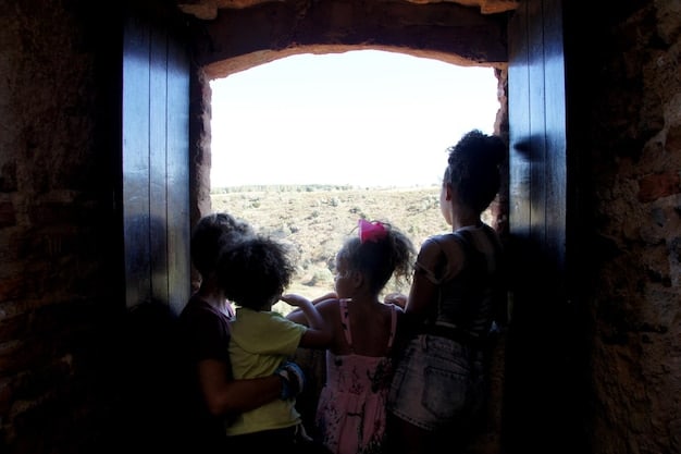 A photo depicting a group of Central American migrants, including women and children, seeking asylum at the US border, highlighting the human cost of restrictive immigration policies.